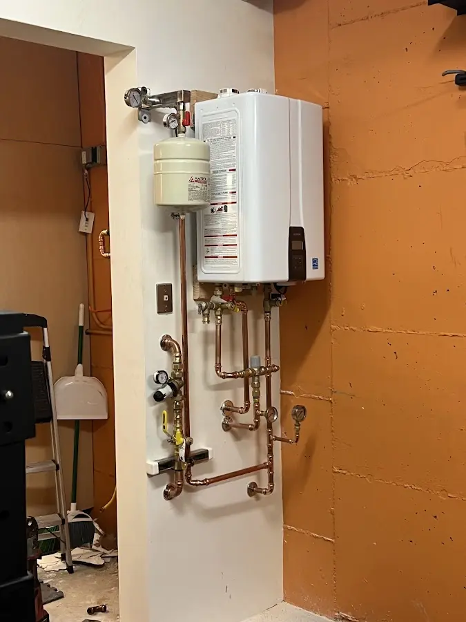 Plumbing technician inspecting water heater connections in Salem Heights